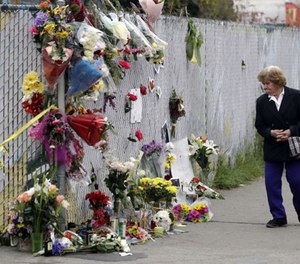 A woman walks past a makeshift memorial near the site of a warehouse fire Monday, Dec. 5, 2016, in Oakland, Calif. (AP Photo/Marcio Jose Sanchez)