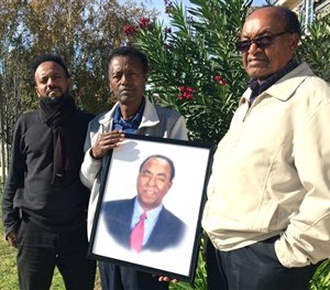 In this Dec. 5, 2015, file photo, family members of Isaac Amanios, from left, Robel Tekleab, Fessehatsion Gebreselassie and Abraham Amanios hold a portait of Isaac Amanios in Fontana, Calif.