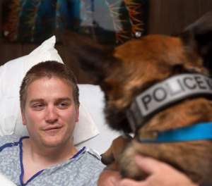 Alabama police officer Webb Sistrunk getting a visit from his canine partner Leon at the hospital in Columbus, Ga. (Joseph T. Paull/Piedmont Columbus Regional via AP)