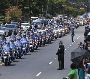 In this July 25, 2016 file photo, the funeral procession for slain Baton Rouge police Corporal Montrell Jackson leaves the Living Faith Christian Center in Baton Rouge, La.