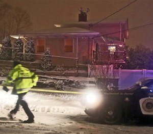 A Harrison police officer stands outside a house where the bodies of a retired police officer and two of his daughters were found, Saturday, Feb. 21, 2015 in Harrison, N.Y.
