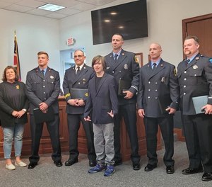 Employees pose with Sean Watson, whose life they saved in March after the boy was trapped in a burning home.