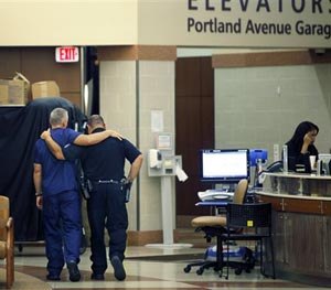 A member of the medical staff and a Rochester Police Officer walk together down the hallway after a news conference at Rochester General Hospital in Rochester, N.Y. early Thursday, Sept. 4, 2014.