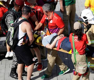 An injured woman is taken away on a backboard after being struck by an overhead television camera that fell from wires suspending it over Olympic Park during the Summer Games in Rio de Janeiro, Brazil, Monday, Aug. 15, 2016. (AP Photo/Robert F. Bukaty)
