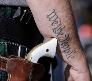 In this Jan. 26, 2015 file photo, a supporter of open carry gun laws, wears a pistol as he prepares for a rally in support of open carry gun laws at the Capitol, in Austin, Texas.