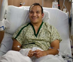 Lt. Peter St. John of Portland Fire & Rescue lies in a bed, recovering from surgery at Legacy Emanuel Medical Center. (Beth Nakamura/The Oregonian via AP)
