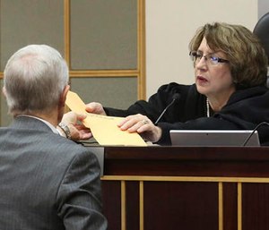 Darryl Bloodworth, left, an attorney for the City of Orlando, hands two envelopes containing 911 calls during the Pulse nightclub shooting to Circuit Judge Margaret Schreiber, Monday, Oct, 31, 2016, in Orlando, Fla. (Red Huber/Orlando Sentinel via AP)