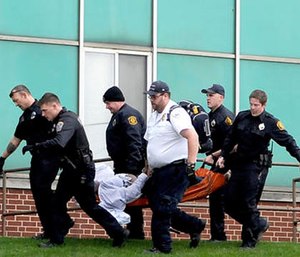 Emergency responders carry a person to an ambulance outside the Turtle Creek Valley Mental Health facility in Homestead, Pa., Friday, Nov. 11, 2016. (Pam Panchak/Pittsburgh Post-Gazette via AP)