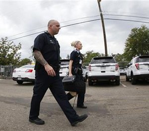 In this Monday, July 18, 2016, photograph taken with a fisheye lens, Denver Police Department officers head out to their patrol car after role call for the swing shift in District 6 in downtown Denver. (AP Image)