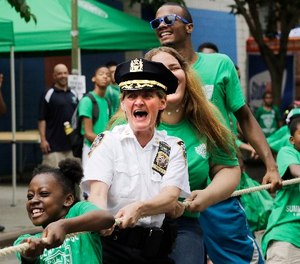 New York Police Department Deputy Chief Kathleen O'Reilly, middle, the commanding officer of Manhattan North, joins in a tug-of-war with campers from the Police Athletic League, Wednesday, July 8, 2015 in New York. The league has been serving New York City youth since 1914.