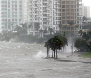 Waves crash over a seawall at the mouth of the Miami River. (Photo/AP)