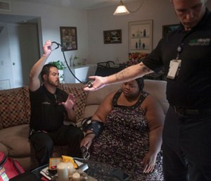 John Farris works with a patient at home.