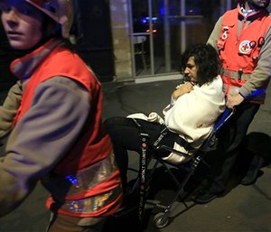 A woman is evacuated from the Bataclan theater after a shooting in Paris.