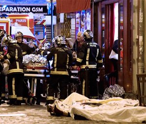 Rescue workers gather at victims in the 10th district of Paris, Friday, Nov. 13, 2015. (AP Photo/Jacques Brinon)