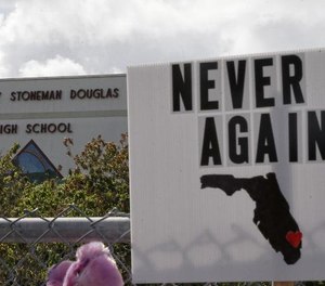 Memorial signs rest on a fence surrounding Marjory Stoneman Douglas High School in Parkland, Florida on February 21, 2018. (Photo/AP)