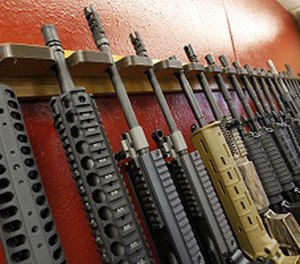 In this July 20, 2012, file photo, a row of different AR-15 style rifles are displayed for sale at the Firing-Line indoor range and gun shop in Aurora, Colo.