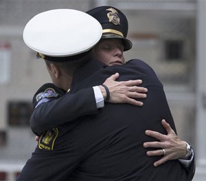 Mourners hug as they arrive at the Cintas Center at Xavier University for the memorial of slain Cincinnati Police Officer Sonny Kim, Thursday, June 25, 2015, in Cincinnati.