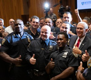 Vice President Mike Pence, right, meets with members of the New York Police Department's football team. (AP Photo/Mark Lennihan)