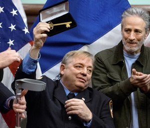 In this Jan. 9, 2016, file photo, retired Fire Department of New York firefighter and Sept. 11 first responder Ray Pfeifer, left, holds the key to the city he was given at New York's City Hall, and is applauded by Jon Stewart. (AP Photo/Craig Ruttle, File)