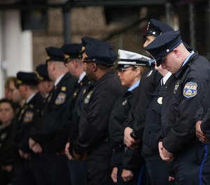 Philadelphia police officers line up after the body of SWAT Cpl. James O'Connor was brought to a hearse at the emergency room entrance at Temple University Hospital in Philadelphia on Friday, March 13, 2020.