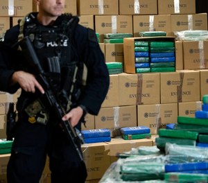 An officer stand guard over a fraction of the cocaine seized from a ship at a Philadelphia port that was displayed at a news conference at the U.S. Custom House in Philadelphia, Friday, June 21, 2019.