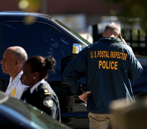 Law enforcement officials gather outside a U.S. post office facility after reports that a suspicious package was found in Atlanta, Monday, Oct. 29, 2018. (AP Photo/David Goldman)