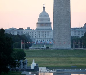 With the U.S. Capitol and Washington Monument in the distance, a man stands at the edge of the Lincoln Memorial Reflecting Pool at sunrise, Sunday, June 7, 2020, in Washington, the morning after massive protests over the death of George Floyd, who died after being restrained by Minneapolis police officers.