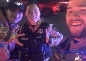 Marvin, a hitchhiker who was trying to make it to court, poses with deputies Redden and Yoon.