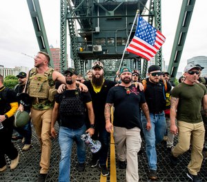 Members of the Proud Boys and other right-wing demonstrators march across the Hawthorne Bridge during an
