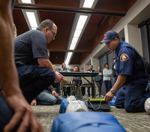 Luis Gonzalez, a Community Emergency Response Team instructor from the Los Angeles County Fire Department, shows trainees how to attach an automated external defibrillator during a CPR demonstration.