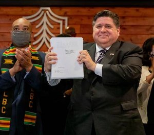 Gov. J.B. Pritzker signs a sweeping criminal justice reform bill into law during a ceremony at Chicago State University on Feb. 22, 2021.