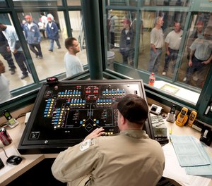 Corrections officer Kaler Hazen works in a control pod in a cell block at the Ellsworth Correctional Facility in Ellsworth, Kan.