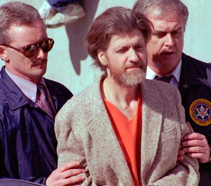 In this April 4, 1996 file photo Theodore John Kaczynski is flanked by federal agents as he is led to a car from the federal courthouse in Helena, Mont.