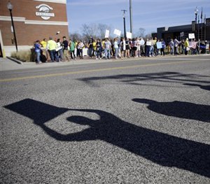 About 100 pro-police demonstrators stand hold signs outside the Ferguson Police Department Sunday, March 15, 2015, in Ferguson, Mo.