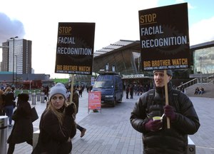 In this Feb. 11, 2020, photo, Silkie Carlo, left, demonstrates in front of a mobile police facial recognition facility outside a shopping centre in London. Image: AP Photo/Kelvin Chan