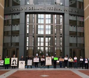 Protesters hold signs in front of the federal building in Oakland, Calif., Wednesday, Dec. 10, 2014.