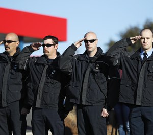 First responders salute as Lubbock Police Officer Nicholas Reyna and Lieutenant/Paramedic Eric Hill are transported to the County Medical Examiner's Office in Fort Worth, Texas. Reyna and Hill died after a vehicle collided with them while responding to an accident on Interstate 27.