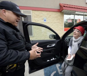 Sgt. Pedro Alexander gives Norma Thompson a gift card as part of the department's initiative to reword those seen practicing safe driving habits. (Photo/TNS)