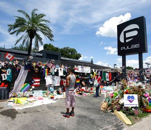Visitors gather at a makeshift memorial outside the Pulse nightclub in Orlando, Fla.