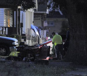 Detroit Police officers check out the damage to a car involved in a police chase on Wednesday, June 24, 2015 in Detroit.