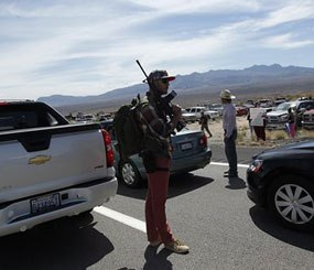 Tyler Lewis, from St. George, Utah, stands in the middle of north bound I-15 with his gun near Bunkerville, Nev. while gathering with other supporters of the Bundy family to challenge the Bureau of Land Management on April 12, 2014.
