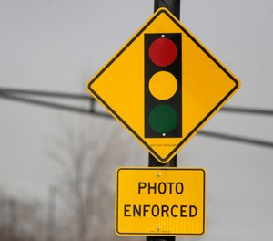 In this Tuesday, Feb. 10, 2015 file photo, a sign warns motorists of the presence of a red light camera in Chicago. (AP Photo/M. Spencer Green, File)