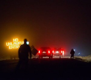 Three SUVs proceed through the Narrows roadblock near Burns, Ore.