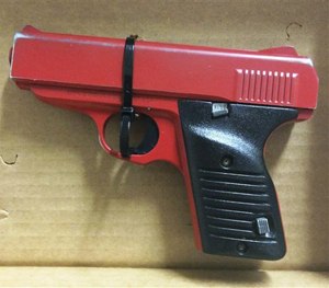 This photo provided by the Hamilton County Sheriff in Cincinnati shows a red-painted, 380-caliber handgun police found during the arrest of 23-year-old Orlando Lowery when responding to a call about a man with a gun.
