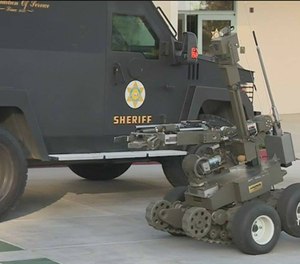 In this photo taken Monday, March 16, 2015, police use a robot attempting to gain entry into an apartment during a standoff an apartment complex in Springfield, Mo.