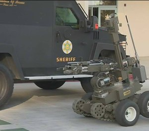 In this photo taken Monday, March 16, 2015, police use a robot attempting to gain entry into an apartment during a standoff an apartment complex in Springfield, Mo.