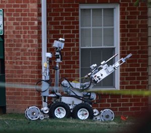 In this photo taken Monday, March 16, 2015, police use a robot attempting to gain entry into an apartment during a standoff an apartment complex in Springfield, Mo. (AP Image)