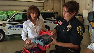 A Rochester Police Officer shows a reporter one of the department''s AEDs