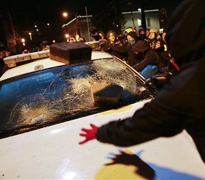 Protesters vandalize a police vehicle outside of the Ferguson city hall in Tuesday, Nov. 25, 2014, in Ferguson, Mo.