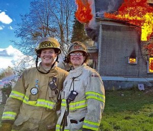 Ramsey Mueller and his mother, Deputy Chief Faith Mueller, stand in front of a controlled training burn on March 26, 2016.